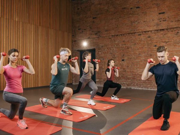 Indoor group workout session with dumbbells focusing on strength and fitness.